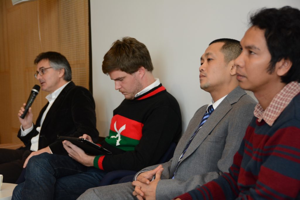 Four men sitting in a panel.